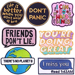 Detailed close-up of 7 colorful embroidered patches with quotes on a white background