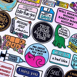 Detailed macro view of assorted feminist and pop culture embroidery patches for DIY clothing