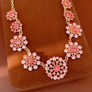 Elegante collar vintage dorado con colgantes de flores caladas con cristales rosas