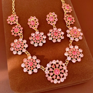 Conjunto de joyas vintage con collar de cristales rosas y pendientes a juego dorados