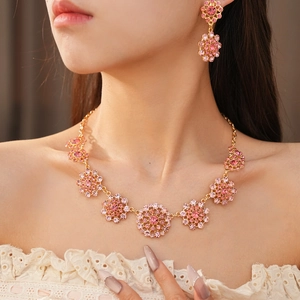 Elegante conjunto de joyas vintage con cristales rosas y diseño circular calado