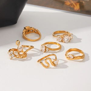 Detailed view of several gold stainless steel rings featuring sparkling cubic zirconia stones