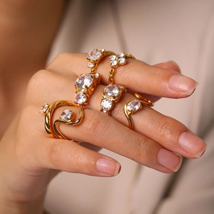 Close-up of elegant gold-plated rings with cubic zirconia stones on fingers