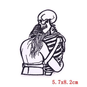 Detail of embroidered patch showing a skull hug design with size 5.7x8.2cm on white background