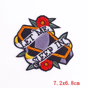 Detailed embroidery of a coffin patch with red flowers and Let Me Sleep In text