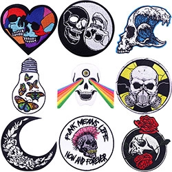 Detailed view of nine punk-style embroidered iron-on patches with skull and rose designs