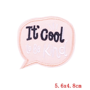 Detail of pink embroidered 'It's Cool to Be Kind' patch for DIY clothing repair