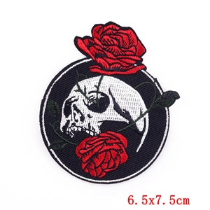Détail d'un écusson brodé tête de mort et roses rouges, taille 6,5x7,5 cm