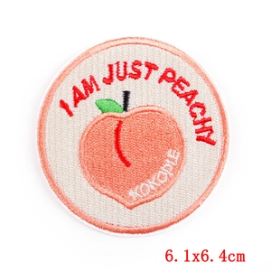 Macro shot of circular peach embroidery patch with I AM JUST PEACHY text and white edges
