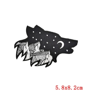 Macro view of wolf head embroidery patch featuring mountain and moon landscape details