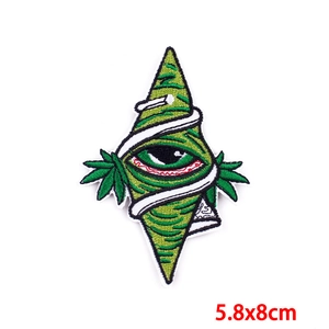 Punk style all-seeing eye embroidered patch with leaf details on white background