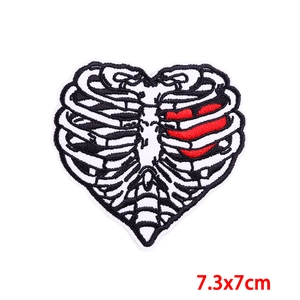 Detailed close-up of a heart and rib cage embroidered patch measuring 7.3x7cm