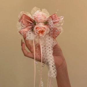 Vue détaillée d'une pince à cheveux à nœud en dentelle rose avec roses et perles