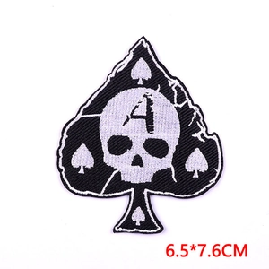 Macro detail of skull and spade embroidered patch with high-density stitching and overlock edge