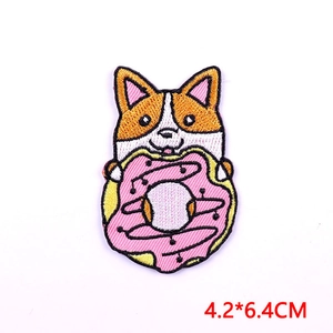 Detail of Corgi dog embroidery patch holding a pink donut, size 4.2x6.4 cm