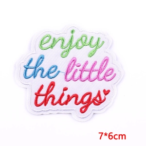 Detail showing embroidered enjoy the little things patch with dimensions 7x6cm
