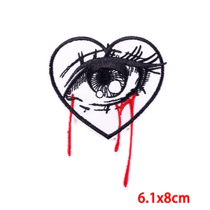 Detailed embroidery view of a heart-shaped eye patch with red blood tears, 6.1x8cm size