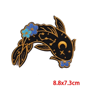 Detailed embroidery of a black koi fish patch with gold stars and blue flowers 8.8x7.3cm