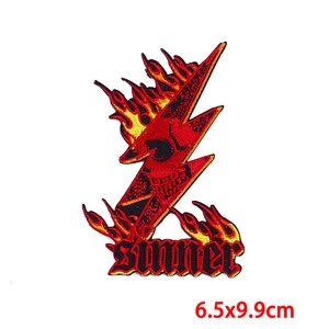 Detail of punk sinner patch featuring red lightning, skull embroidery and flame patterns
