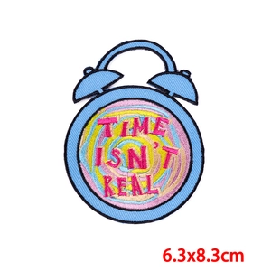 Detail showing alarm clock embroidered patch with Time Isn't Real text in 6.3x8.3cm size