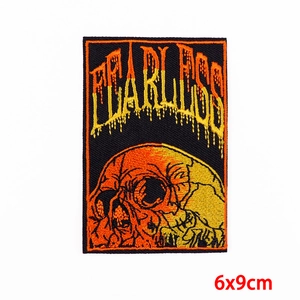 Detailed view of Fearless skull embroidered patch with 6x9cm dimension labels