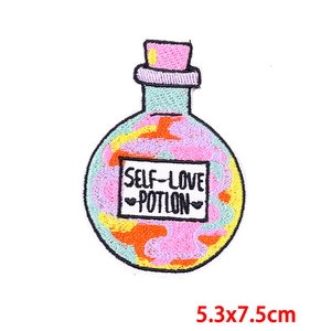 Detailed embroidery of a self-love potion bottle patch with colorful threads