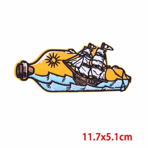 Détails de l'écusson brodé représentant un bateau dans une bouteille marine