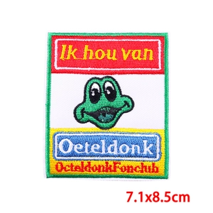 Close-up of embroidered green frog patch with colorful stripes for carnival apparel