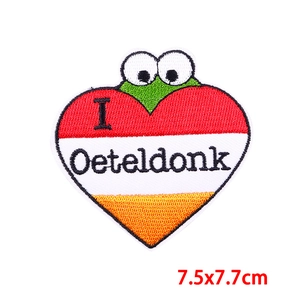 Detail of Oeteldonk heart embroidery patch with green frog and striped background