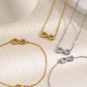 Detailed macro view of 18K gold and silver infinity necklaces with pavé crystals.