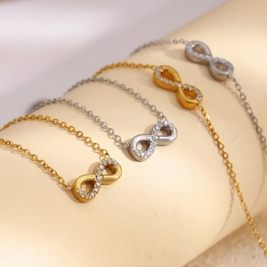 Detail of gold and silver infinity pendant necklaces with sparkling rhinestones on fine chains.