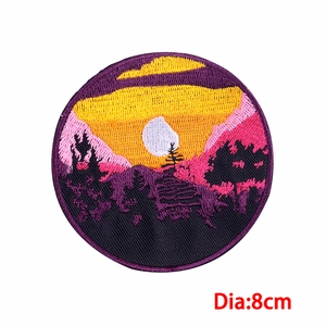 Detailed close-up of 8cm circular mountain sunset embroidered patch with purple border