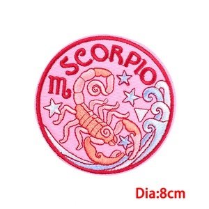 Detail of 8cm Scorpio zodiac embroidery patch with orange scorpion and star patterns