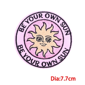 Detailed embroidery of sun patch with BE YOUR OWN SUN text and pink border finish