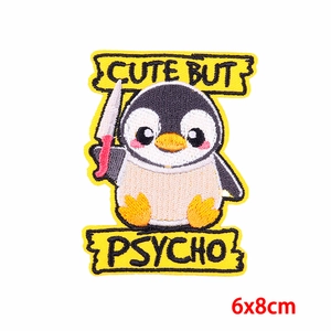 Detail of embroidered penguin patch with Cute But Psycho text and knife in 6x8cm size