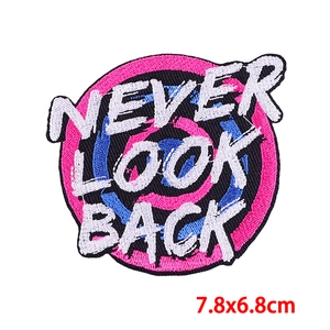 Detail of embroidered patch showing Never Look Back quote and 7.8x6.8cm dimensions