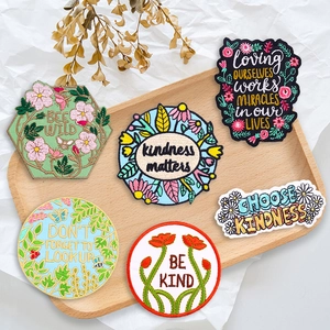 Detail von 6 Stickpatches mit Blumen, Bienen und Schmetterlingen auf einem Holztablett
