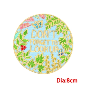 Detail eines 8cm runden Stickaufnähers mit bunten Beeren und Bienenmotiv-Design