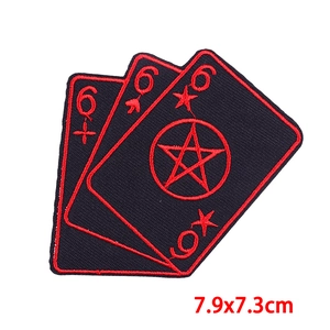 Close-up of punk style poker card embroidered patches with red and black stitching detail