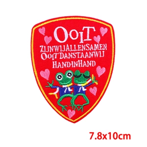 Detailed embroidery of red shield patch with Ooit text and green frogs, 7.8x10cm