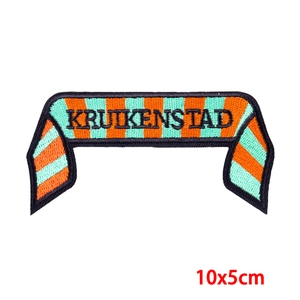 Macro detail of Kruikenstad striped embroidery patch with orange and green diagonal lines
