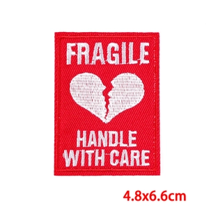 Detailed embroidery of a red Fragile patch with broken heart and dimensions of 4.8x6.6cm