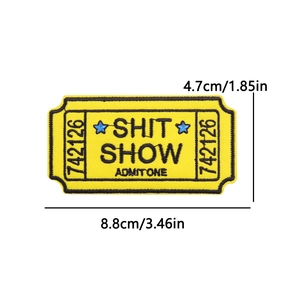 Detail of yellow embroidered Shit Show movie ticket patch with black text for clothing