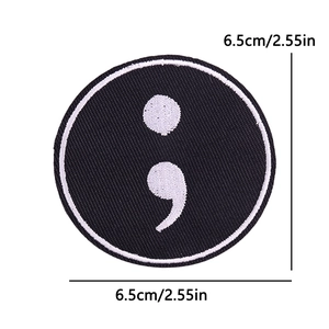 Detail of a 6.5cm round embroidered semicolon patch with black and white stitching