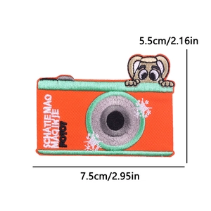 Detailed embroidery patch featuring an orange cartoon camera with animal and green border