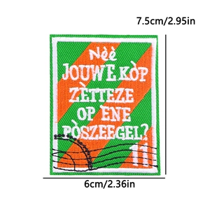 Detail shot of embroidered Kruikenstad patch with orange and green stripes and size specs
