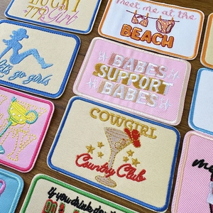 Set of Western cowboy embroidery patches with Cowgirl lettering on a wooden desk