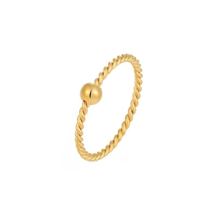 Primo piano di un sottile anello in acciaio al titanio dorato da 1 mm con perlina lucida.