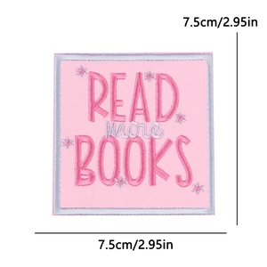 Macro shot of pink embroidered patch featuring Read More Books text and flowers