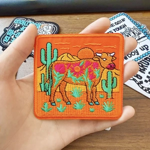 Embroidered square desert patch with a brown buffalo and cactus on bright orange fabric